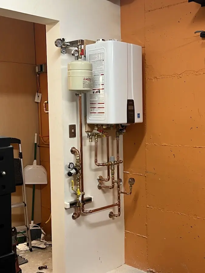 Plumbing technician inspecting water heater connections in Russellville